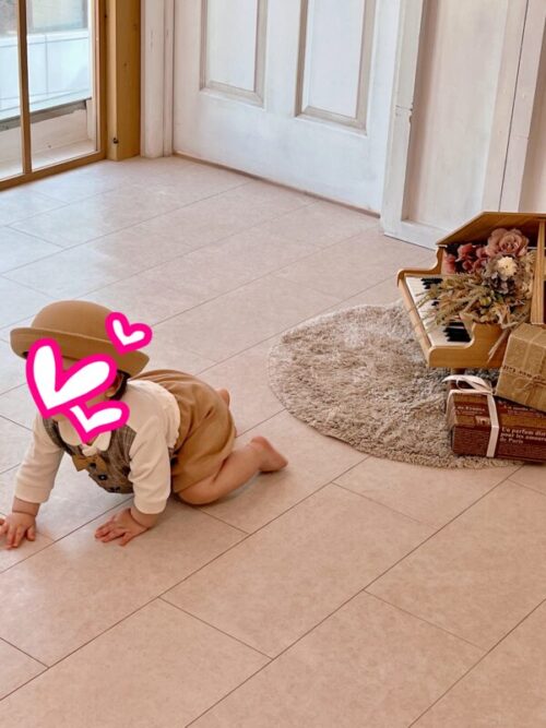 写真館にて撮影中にハイハイで逃げようとする赤ちゃんの写真。ミニピアノ。